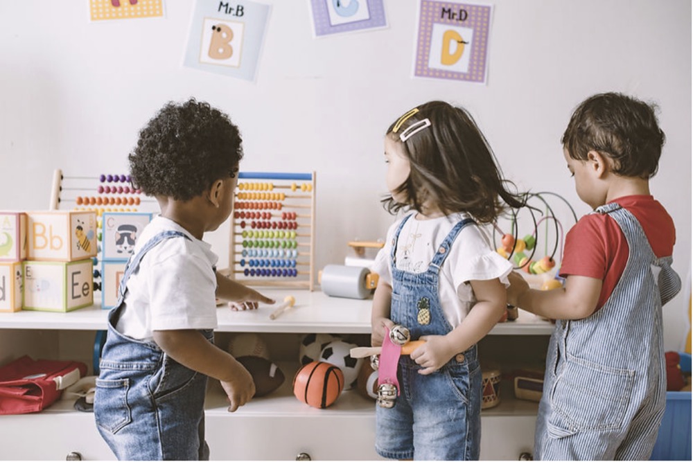 Three children in a playroom environment